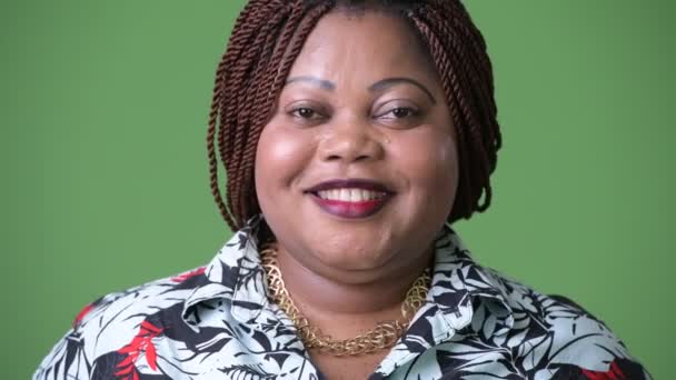 Overweight beautiful African woman against green background — Stock Video