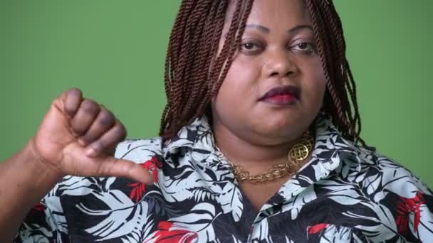 Übergewichtige schöne Afrikanerin vor grünem Hintergrund — Stockvideo