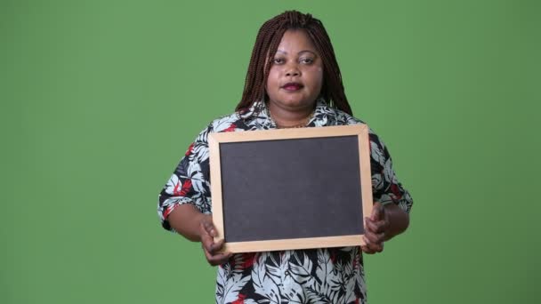 Overweight beautiful African woman against green background — Stock Video