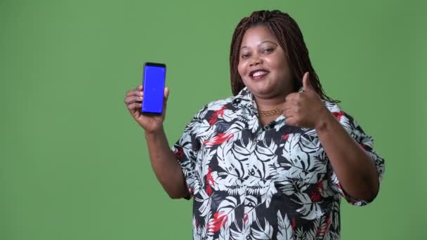 Overweight beautiful African woman against green background — Stock Video