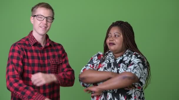 Overweight African woman and young Scandinavian man together against green background — Stock Video