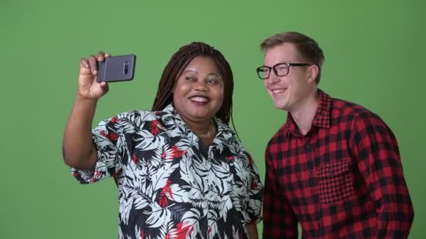 Mujer africana con sobrepeso y joven hombre escandinavo juntos contra fondo verde — Vídeo de stock