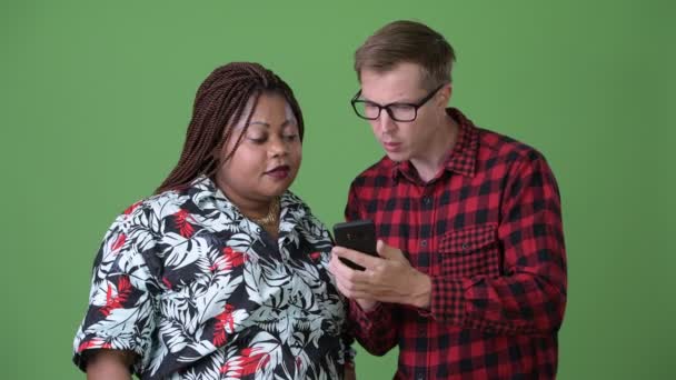 Толстая африканская женщина и молодой скандинавский мужчина вместе на зеленом фоне — стоковое видео