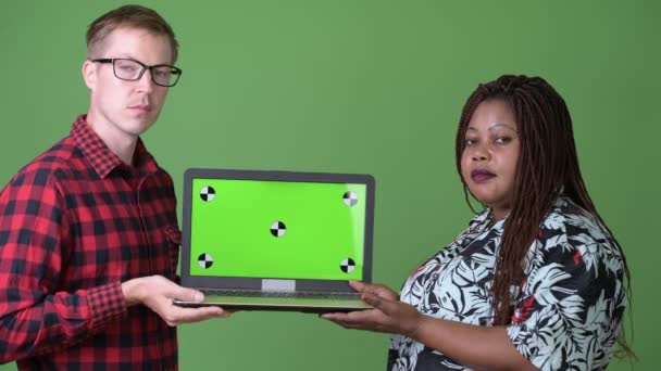 Nadwagą African kobieta i młody mężczyzna skandynawskich razem na zielonym tle — Wideo stockowe