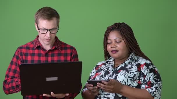 Overweight African woman and young Scandinavian man together against green background — Stock Video