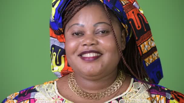 Sobrepeso bela mulher africana vestindo roupas tradicionais contra fundo verde — Vídeo de Stock