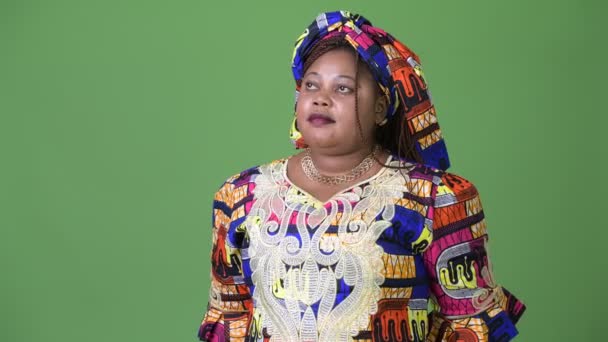 Mujer africana hermosa con sobrepeso que usa ropa tradicional sobre fondo verde — Vídeos de Stock