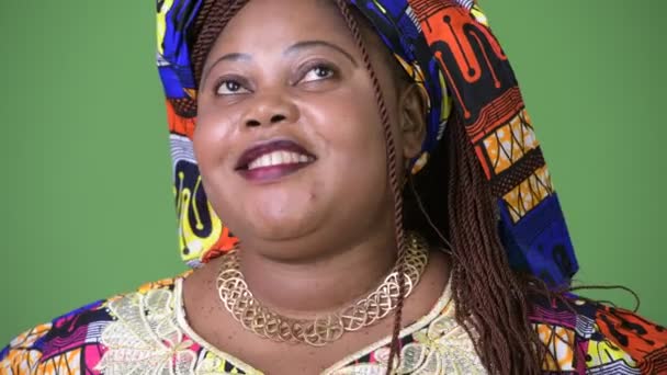 Överviktig vacker afrikansk kvinna bär traditionella kläder mot grön bakgrund — Stockvideo