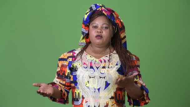 Mujer africana hermosa con sobrepeso que usa ropa tradicional sobre fondo verde — Vídeo de stock