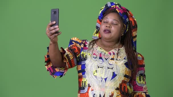 Sovrappeso bella donna africana indossa abiti tradizionali sullo sfondo verde — Video Stock