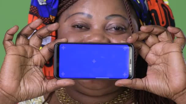 Túlsúlyos gyönyörű afrikai nő visel hagyományos ruházat-háttere zöld — Stock videók