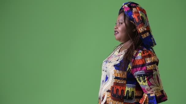 Surpoids belle femme africaine portant des vêtements traditionnels sur fond vert — Video