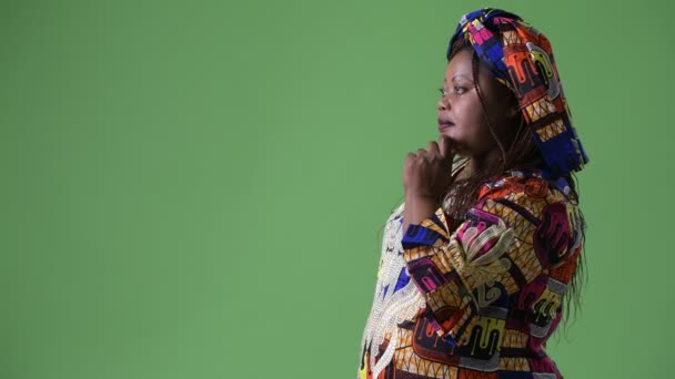 Surpoids belle femme africaine portant des vêtements traditionnels sur fond vert — Video