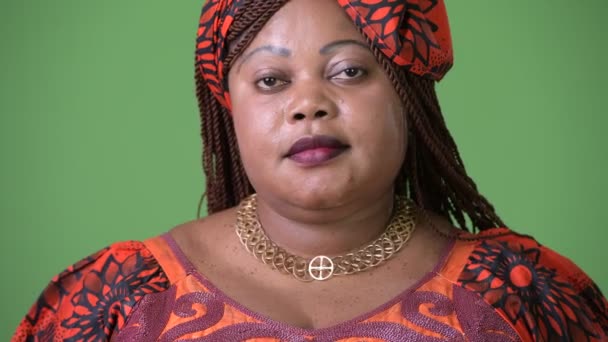 Nadváhou krásná Africká žena nosí tradiční oděv proti zeleným pozadím — Stock video