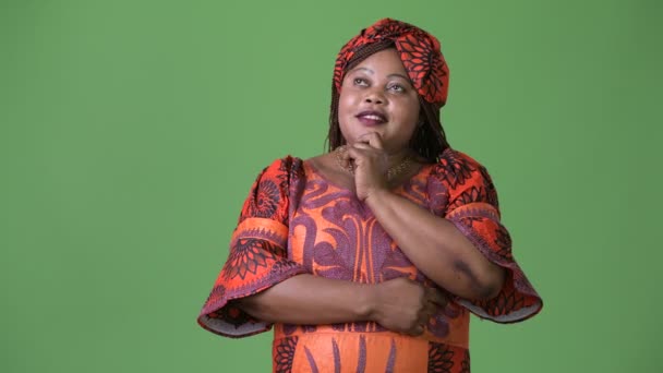 超重的美丽的非洲妇女穿着传统服装反对绿色背景 — 图库视频影像
