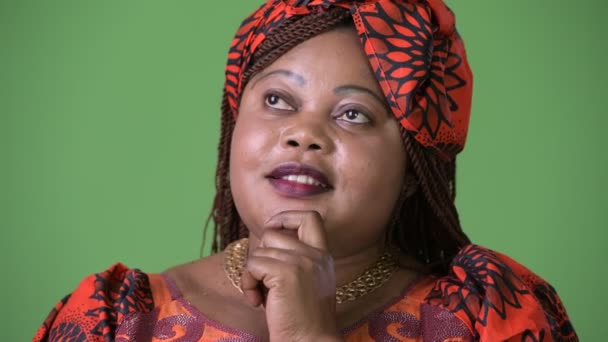 Overgewicht mooie Afrikaanse vrouw dragen traditionele kleding tegen groene achtergrond — Stockvideo