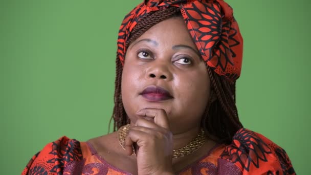 Overweight beautiful African woman wearing traditional clothing against green background — Stock Video