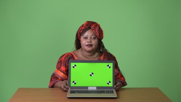 Mujer africana hermosa con sobrepeso que usa ropa tradicional sobre fondo verde — Vídeo de stock