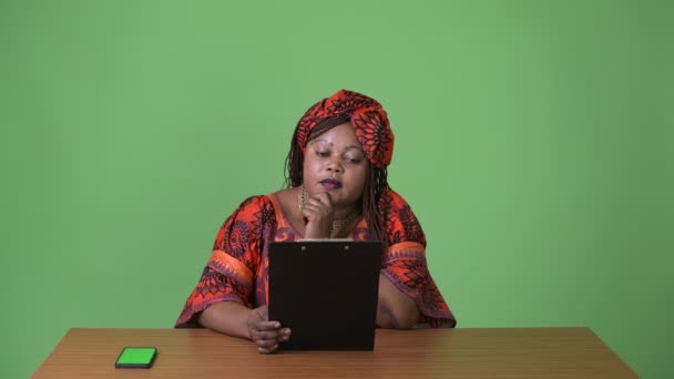 Mujer africana hermosa con sobrepeso que usa ropa tradicional sobre fondo verde — Vídeo de stock