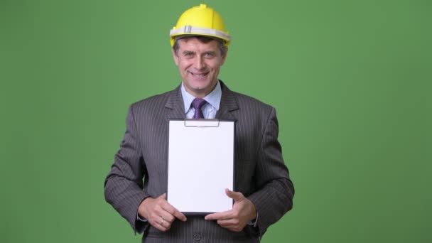 Mature handsome businessman against green background — Stock Video