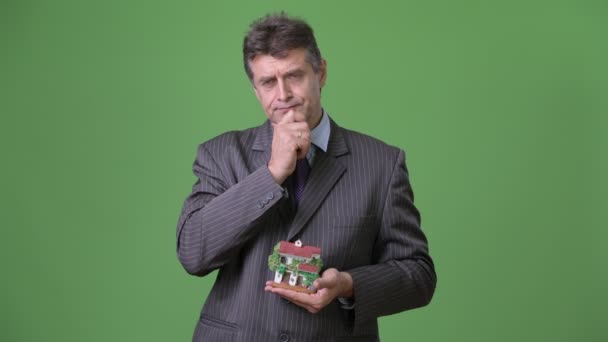 Зрелый красивый бизнесмен на зеленом фоне — стоковое видео