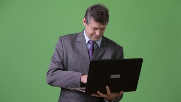 Зрелый красивый бизнесмен на зеленом фоне — стоковое видео
