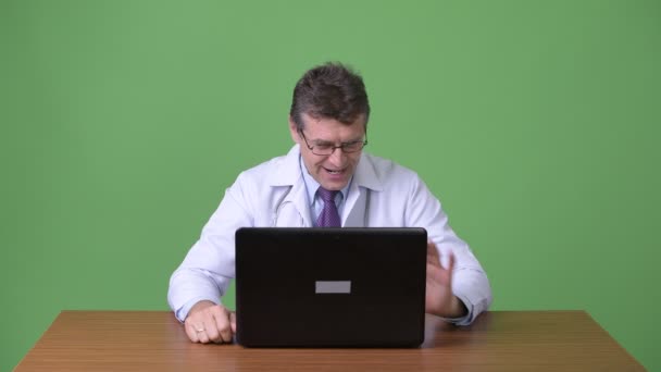 성숙한 잘생긴 남자 의사 녹색 배경 — 비디오