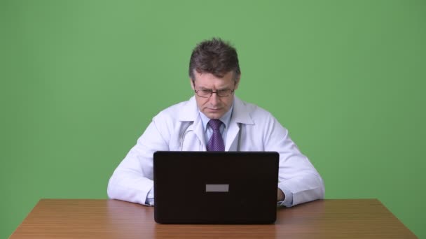 Zralý muž Doktor před zeleným pozadím — Stock video