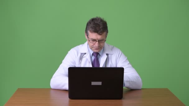 성숙한 잘생긴 남자 의사 녹색 배경 — 비디오