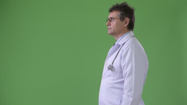 Érett jóképű férfi orvos ellen zöld háttér — Stock videók