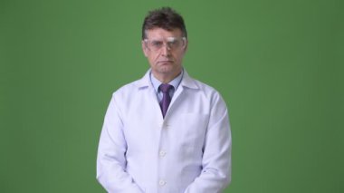 Olgun yakışıklı adam doktor yeşil bir arka plana dayanır