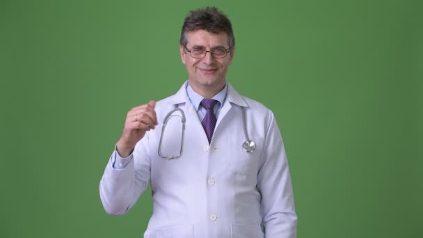 Dojrzały mężczyzna przystojny lekarz na zielonym tle — Wideo stockowe