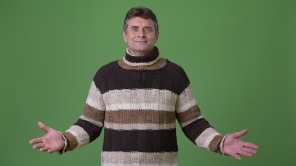 Maturo bello uomo indossare dolcevita maglione contro verde sfondo — Video Stock