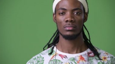 Yeşil bir arka plana dayanır dreadlocks ile genç Afrika yakışıklı