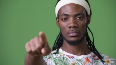 Yeşil bir arka plana dayanır dreadlocks ile genç Afrika yakışıklı