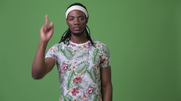 Joven hombre africano guapo con rastas sobre fondo verde — Vídeo de stock