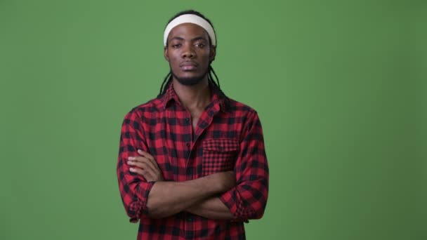 Pěkný africký mladík s dredy před zeleným pozadím — Stock video