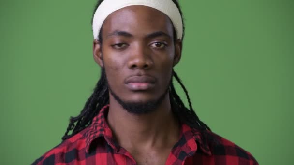 Jovem e bonito homem africano com dreadlocks contra fundo verde — Vídeo de Stock