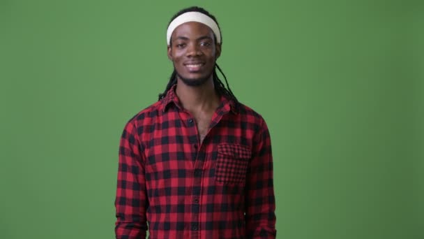 Młody przystojny mężczyzna Afryki z dredy na zielonym tle — Wideo stockowe