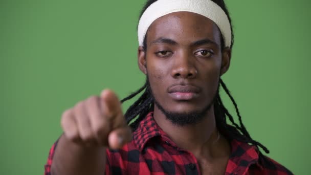 Joven hombre africano guapo con rastas sobre fondo verde — Vídeo de stock