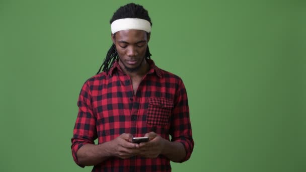 Joven hombre africano guapo con rastas sobre fondo verde — Vídeos de Stock