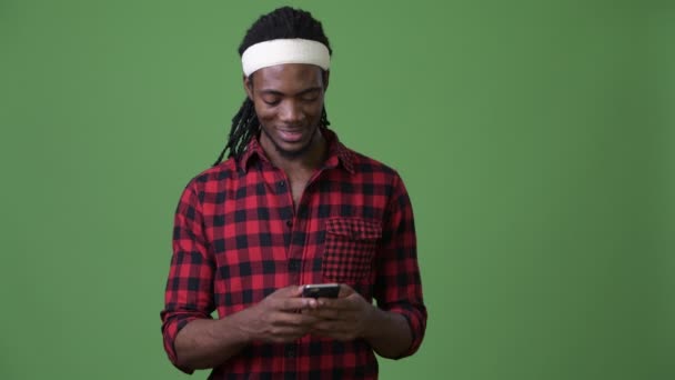 Ung vacker afrikansk man med dreadlocks mot grön bakgrund — Stockvideo