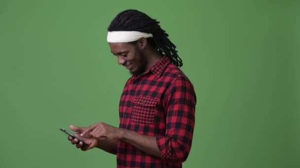 Ung vacker afrikansk man med dreadlocks mot grön bakgrund — Stockvideo
