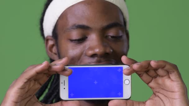 緑背景にドレッドヘアを持つ若いハンサムなアフリカ人 — ストック動画