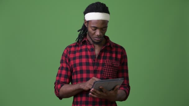 Joven hombre africano guapo con rastas sobre fondo verde — Vídeo de stock