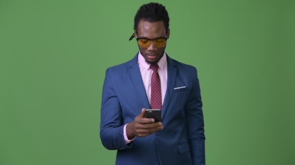 Ung vacker afrikansk affärsman med dreadlocks mot grön bakgrund — Stockvideo