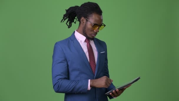 Jovem bonito empresário africano com dreadlocks contra fundo verde — Vídeo de Stock