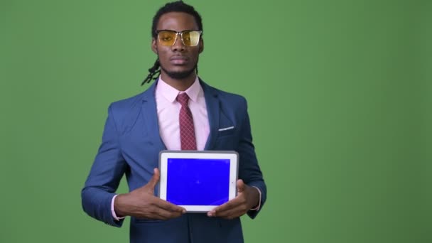 Joven hombre de negocios africano guapo con rastas sobre fondo verde — Vídeos de Stock
