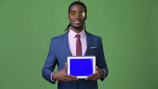 Joven hombre de negocios africano guapo con rastas sobre fondo verde — Vídeos de Stock