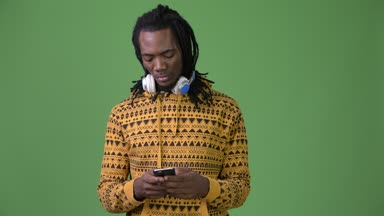 Yeşil bir arka plana dayanır dreadlocks ile genç Afrika yakışıklı